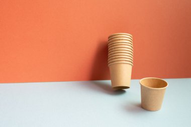 Gri masada tek kullanımlık kağıt bardaklar. kırmızı duvar arkaplanı