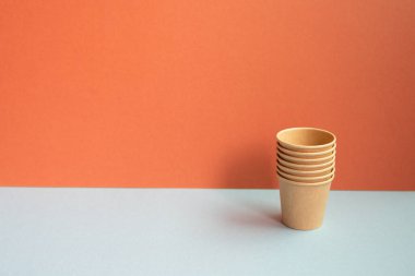 Gri masada tek kullanımlık kağıt bardaklar. kırmızı duvar arkaplanı