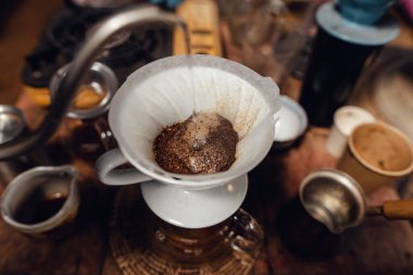 Barista pouring hot water on ground coffee with paper filter to making a drip coffee,Close-up of brewing coffee