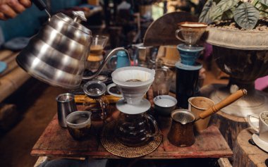 Barista pouring hot water on ground coffee with paper filter to making a drip coffee,Close-up of brewing coffee