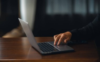 Adam evde dizüstü bilgisayarla çalışıyor, dizüstü bilgisayarla çalışıyor.