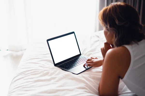 Caucasian woman laying on bed using laptop,Laptop on empty bed