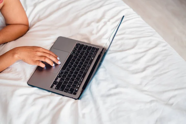 Caucasian woman laying on bed using laptop,Laptop on empty bed