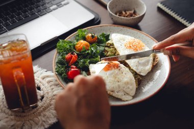 Sağlıklı avokado kızarmış yumurtalı tost kahvaltısı masada.