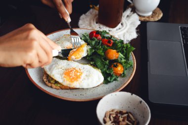 Sağlıklı avokado kızarmış yumurtalı tost kahvaltısı masada.