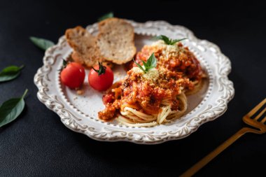 Siyah arka planda domates soslu ve peynirli spagetti.