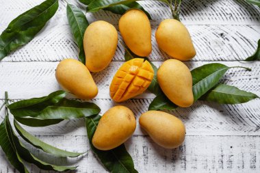 Beyaz ahşap üzerinde sarı olgun mango