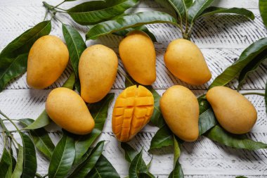 Beyaz ahşap üzerinde sarı olgun mango