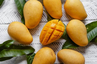 Beyaz ahşap üzerinde sarı olgun mango