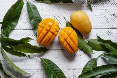 Beyaz ahşap üzerinde sarı olgun mango