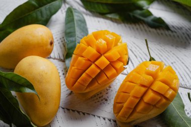 Beyaz ahşap üzerinde sarı olgun mango