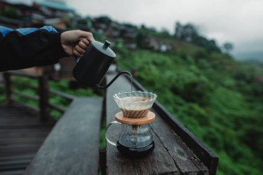 Evin balkonuna yeşil ağaçlar manzaralı kahve dök.