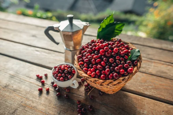 Sepette kahve çekirdeği ve ahşap bir masanın üzerine kahve.