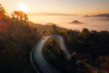 Dağ vadisindeki yol manzarası, Altın ışıklı dağ yolu ve sabah sisli denizi.