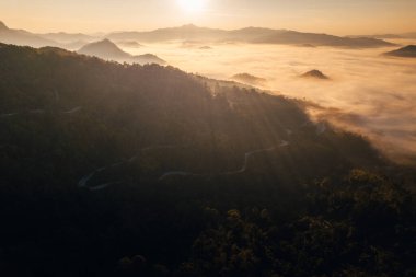 Dağ vadisindeki yol manzarası, Altın ışıklı dağ yolu ve sabah sisli denizi.