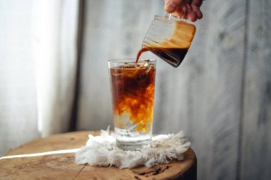 Bardaktaki soğuk suya bir bardak kahve dolduruyorum.