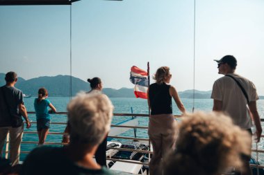 İnsanlar ve arabalar adaya giden teknelerde