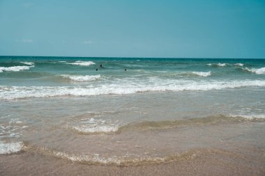 Gün boyunca adada kumsal ve dalgalar.