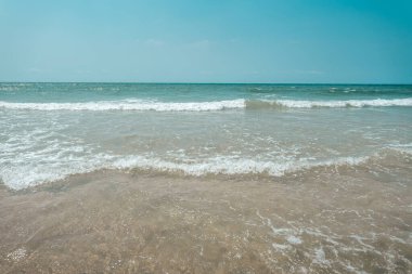 Gün boyunca adada kumsal ve dalgalar.