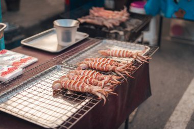 Adadaki bir markette ızgarada mürekkep balığı ızgara yapmış.