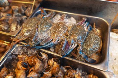 Adadaki bir deniz ürünleri restoranının önündeki tepside taze yengeçler.