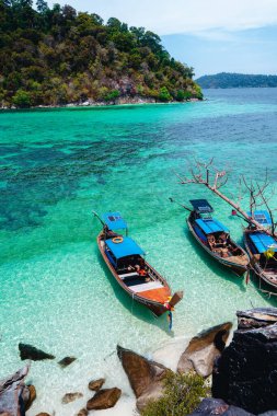 Adadaki temiz sahilde tahta bir tekne.