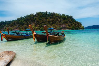 Adadaki temiz sahilde tahta bir tekne.