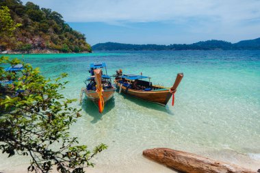 Adadaki temiz sahilde tahta bir tekne.