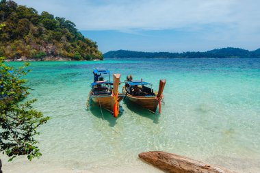 Adadaki temiz sahilde tahta bir tekne.