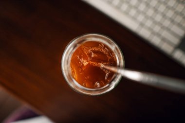 Evdeki masanın üstündeki kupada buzlu kahve.