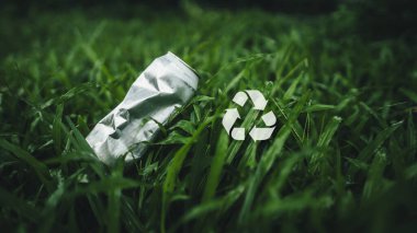 Alüminyum teneke kutular, çimenlikte alüminyum çöp kutuları, çevre simgeleriyle birlikte geri dönüşüm.