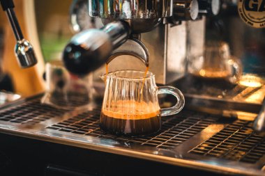 Espresso makineden bardağa, kahve bardağa akıyor.