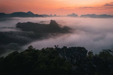 Morning fog and mountains as the sun rises from above clipart