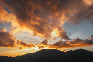 Alacakaranlıkta ve dağlarda altın bulutlar, akşam bulutları ve gökyüzü arka planı,