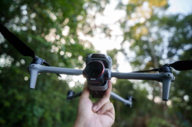 Uçmadan önce kameralı insansız hava aracı, yeşil ormanda bokeh arka plan