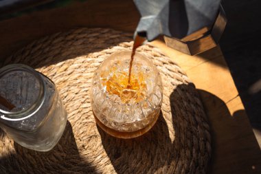 Sabah evde buzlu bir bardağa kahve döküldü, sabah kahve içildi.