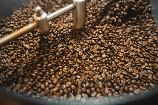 Жареный коричневый кофе в зернах в машине, кофейных зерен фон, качество кофе в зернах