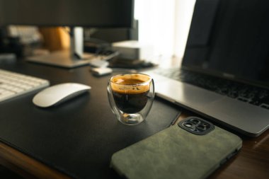 Evdeki masada, laptopta ve bilgisayarda bardakta çekilmiş kahve..
