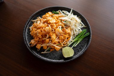 Marketten Pad Thai, evdeki masada bir tabağa yerleştirildi..