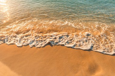 Kumsalda kum ve sabah deniz dalgaları, turuncu ton..