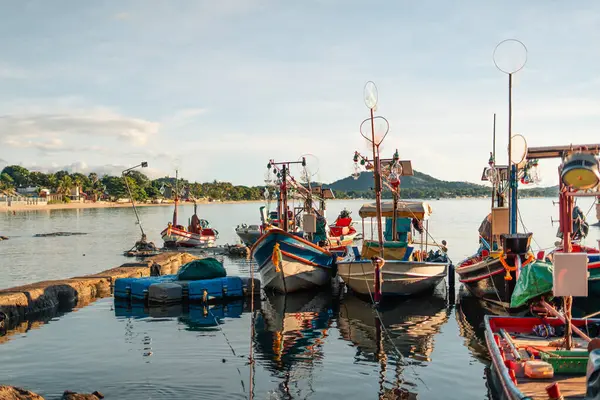 Sabahları balıkçı limanı, taştan bir iskele boyunca demirlemiş çeşitli renkli balıkçı tekneleriyle.