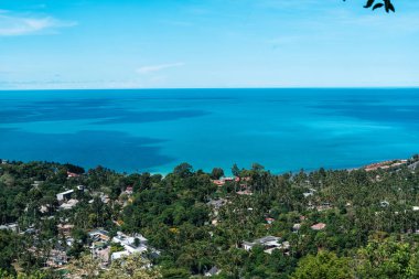 Koh Samui 'nin muhteşem panoramik manzarası sarmal kıyı şeridi ve yemyeşil ormanlarla çelişiyor tepeler ve vadileri kaplıyor.