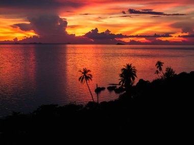 Okyanus üzerinde gün batımı, derin turuncu ve mor renkler döküm su ve gökyüzü üzerinde.