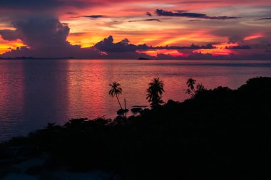 Okyanus üzerinde gün batımı, derin turuncu ve mor renkler döküm su ve gökyüzü üzerinde.