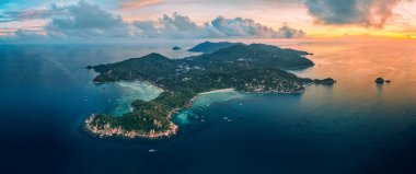 Panoramik hava fotoğrafı Koh Tao ve Koh Nang Yuan 'ın şafak vakti nefes kesici güzelliklerini gösteriyor. Gökyüzü parlak turuncu, pembe ve açık mavi renklerle süslenmiş..