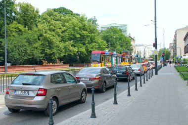 Lodz - Polonya. 18 Haziran 2019: Şehirde yoğun saatler. Gündüz trafiğinin en yoğun olduğu saat. Öğle yemeği saatinde araba kuyruğu. Şehir ulaşımı. Yoldaki araba kuyruğu. Şehirdeki trafik sıkışıklığı. Araç trafik sıkışıklığında duruyor