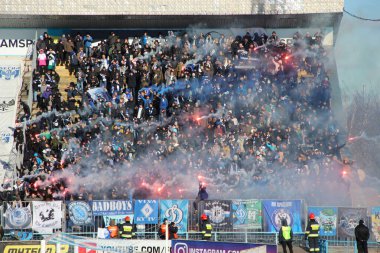Chernihiv - Ukrayna. 28 Şubat 2020: Maç sırasında Desna Chernihiv 'in futbol taraftarları. Gençler Ukrayna futbol kulübü Desna Chernihiv 'in hayranları. duman bombaları futbol maçını kirletiyor