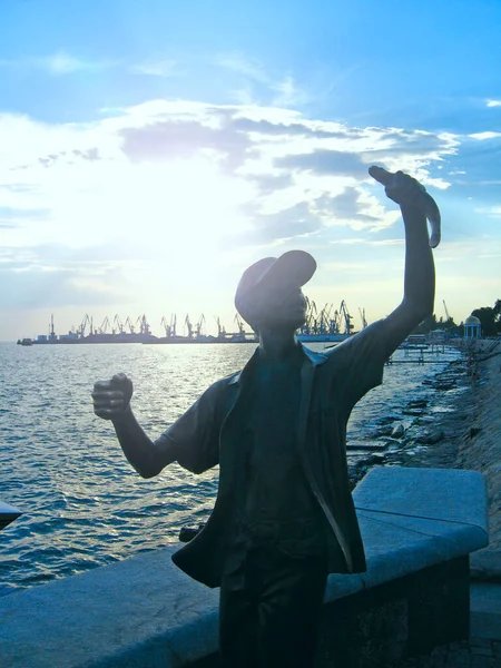 stock image Berdyansk-Ukraine 21 June 2012:Monument to fisherman and fish against backdrop of sunset in Ukrainian city of Berdyansk. Statue of boy with caught fish in Berdyansk.