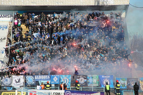 Chernihiv - Ukraine. 28 February 2020: football fans of Desna Chernihiv support team during match. Young people are fans of Ukrainian football club Desna Chernihiv. smoke bombs diring football game