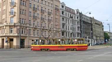 Lodz - Polonya. 17 Ağustos 2019: Lodz caddesindeki kırmızı tramvay. Şehir boyunca giden renkli tramvay. Modern yolcu taşımacılığı. Şehir tramvayı demiryoluna gidiyor.